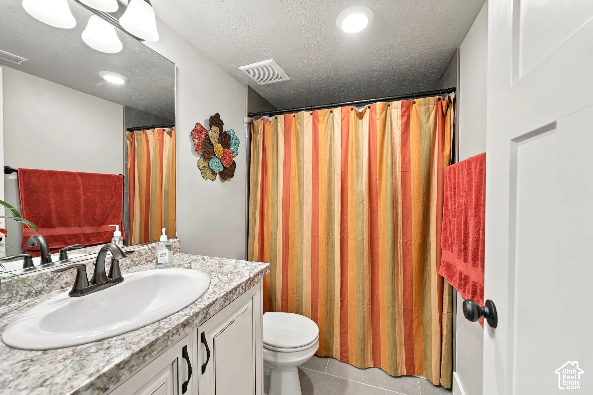 Bathroom featuring a vanity with an oval sink, dark bronze hardware, a large wall mirror, and overhead lighting
