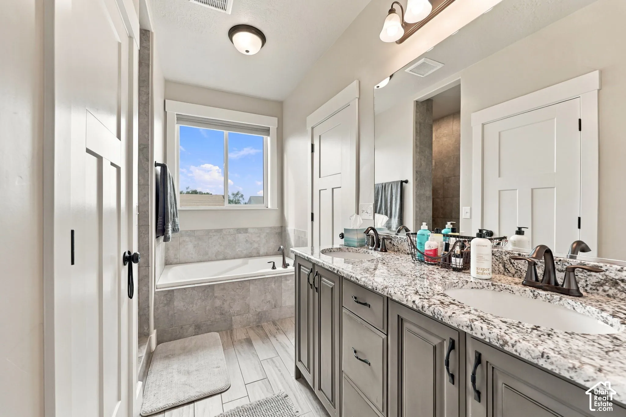 Dual vanity with a stone-look countertop, integrated double sinks, and dark bronze fixtures