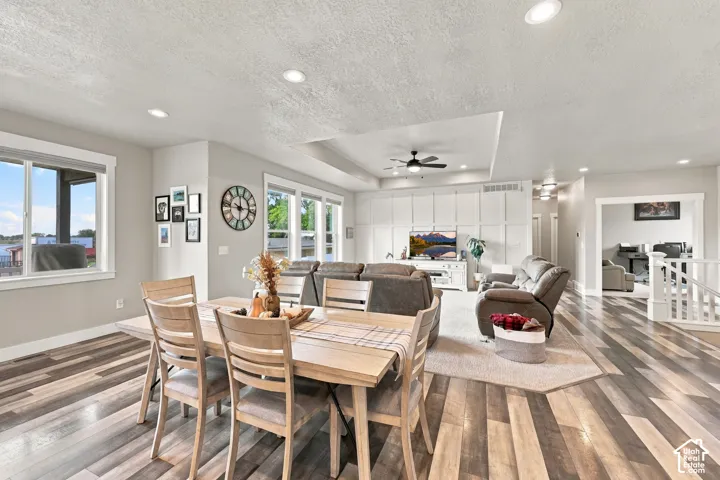 Recessed lighting, wood-finish flooring, multiple windows, built-in wall paneling, and an open layout