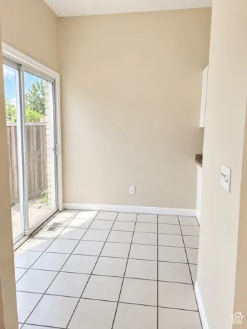 Sliding glass door, tiled flooring, wood fence, upper cabinet, and countertop