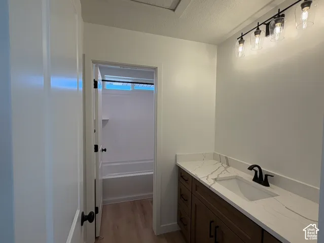 Warm wood-finish vanity with a white rectangular sink