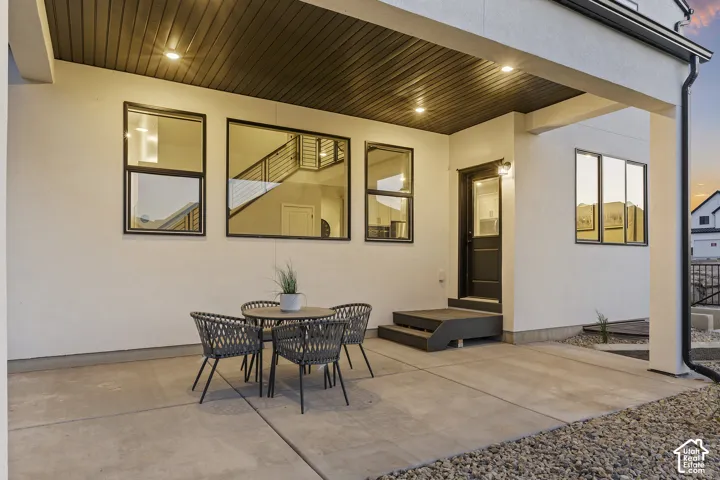 Covered patio with recessed lighting, concrete flooring, and an exterior door