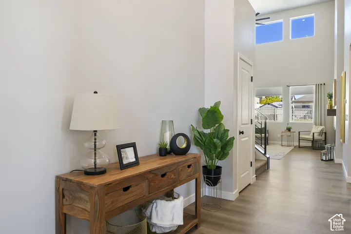 Two-story entry with high ceilings, wood-finish flooring, and upper wall windows