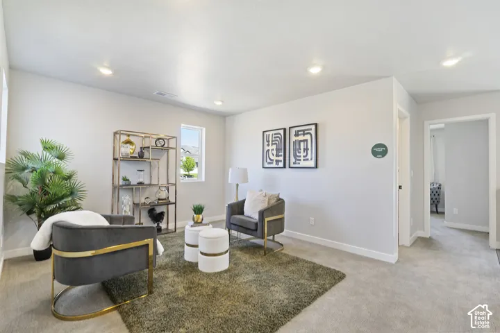 Recessed lighting, wall-to-wall carpeting, and a window with natural light