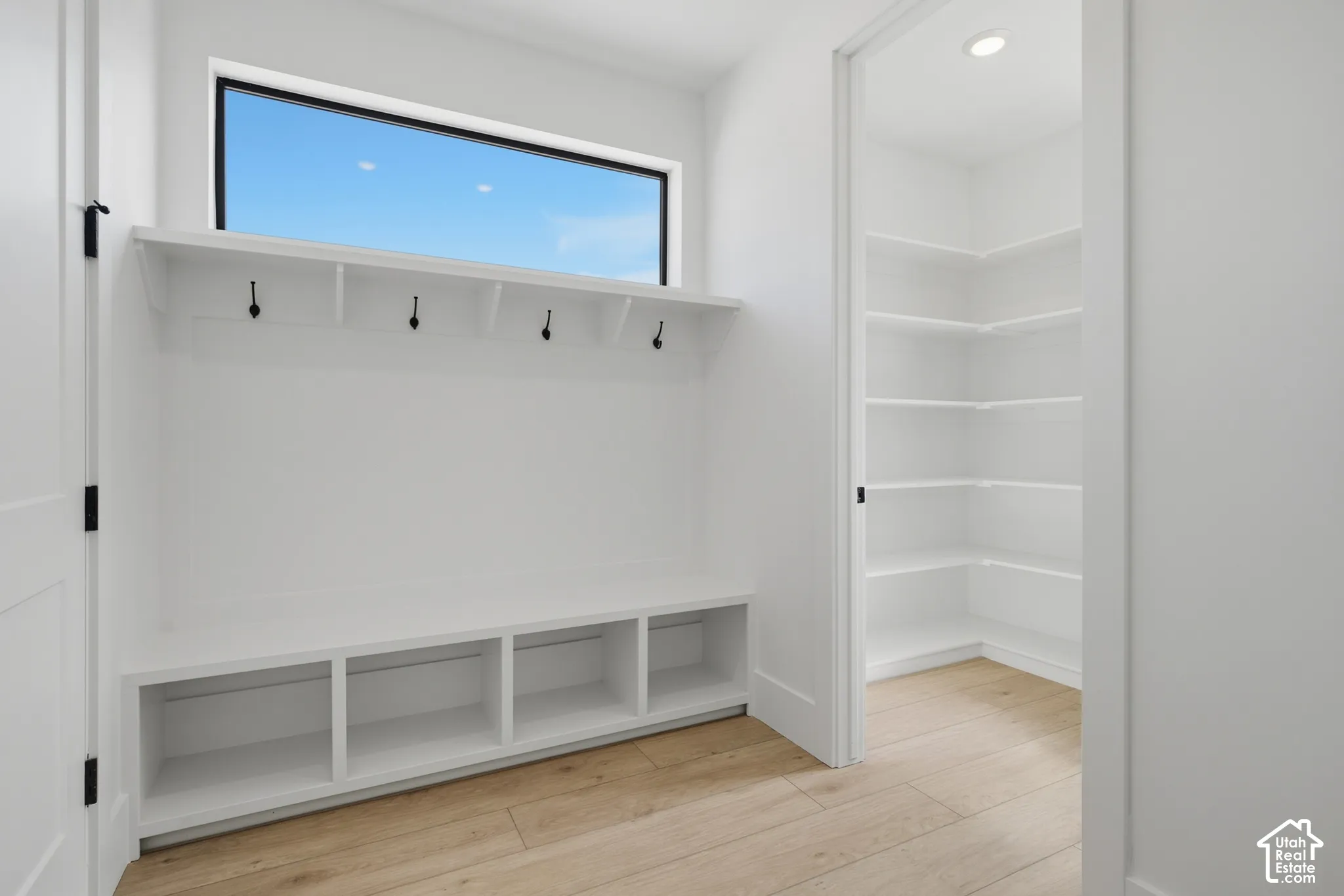 Built-in bench seating with cubby storage, upper shelf, and coat hooks