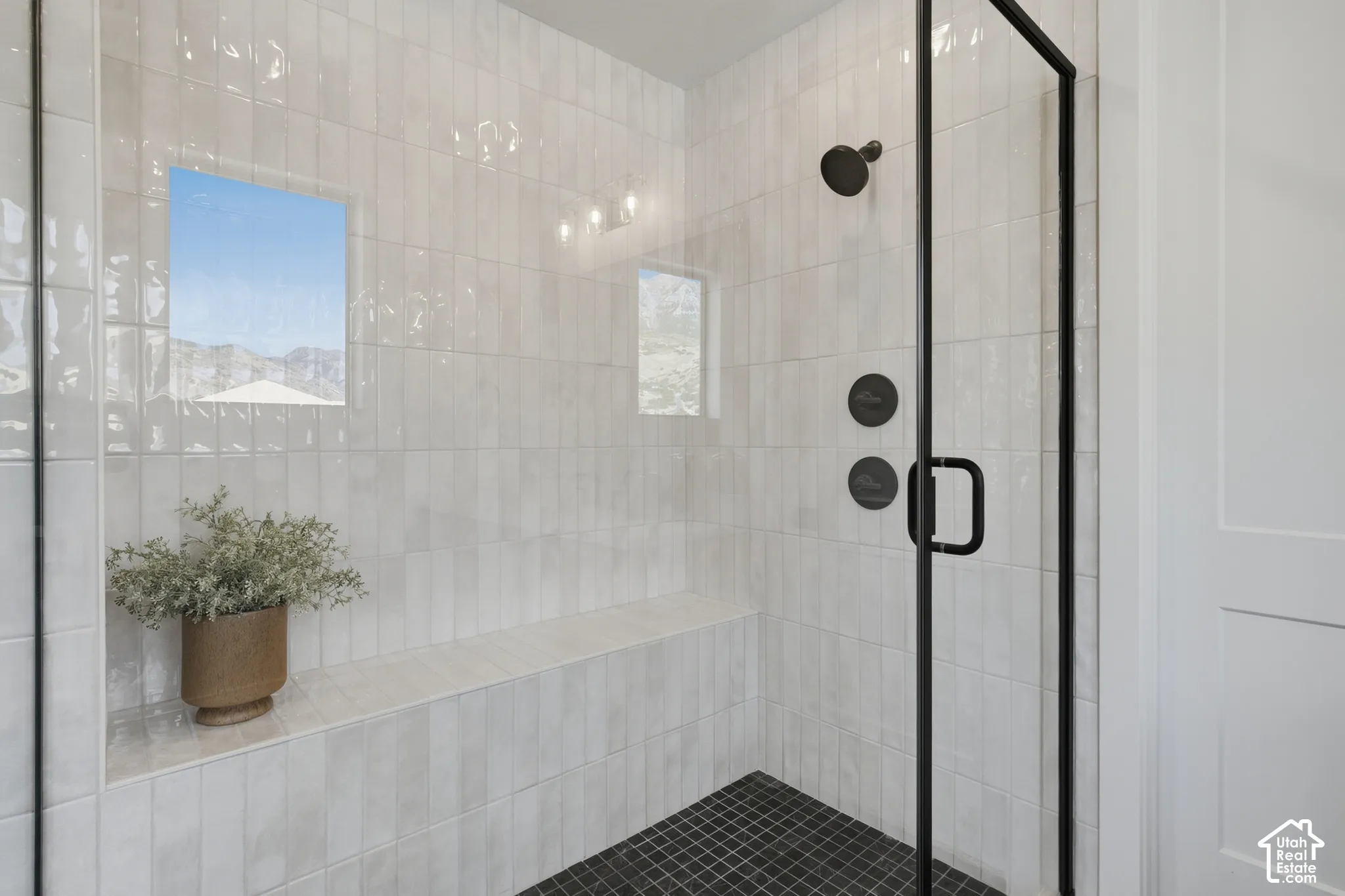 Walk-in shower with full-height tile surround, integrated bench, and mosaic tile flooring