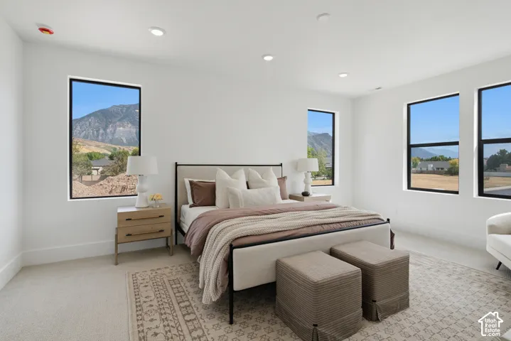 Recessed ceiling lighting, multiple large windows, and light-toned wall-to-wall carpeting