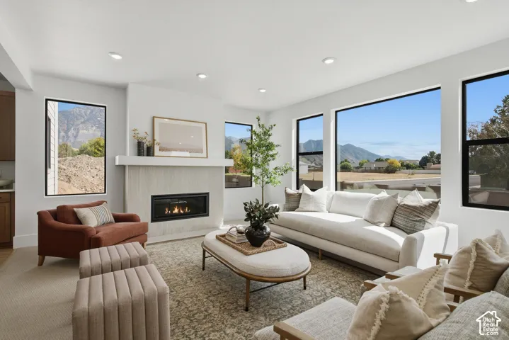 Recessed lighting illuminating a spacious living area featuring a fireplace with a light wood-finish surround and white mantel