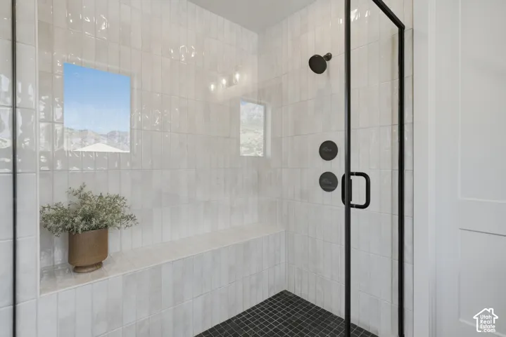 Walk-in shower with full-height tile surround, integrated bench, and mosaic tile flooring