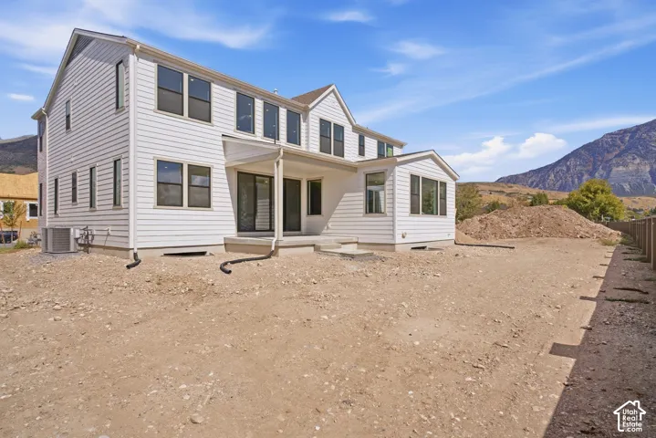 White siding exterior with multiple windows, covered patio, and a sunroom extension