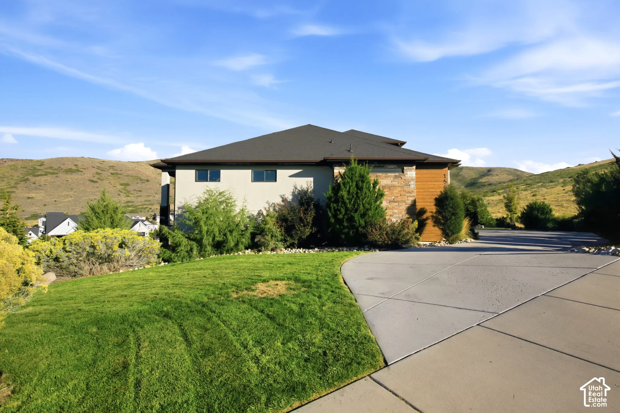 Exterior featuring a dark shingle roof, light-colored siding, and stone accents