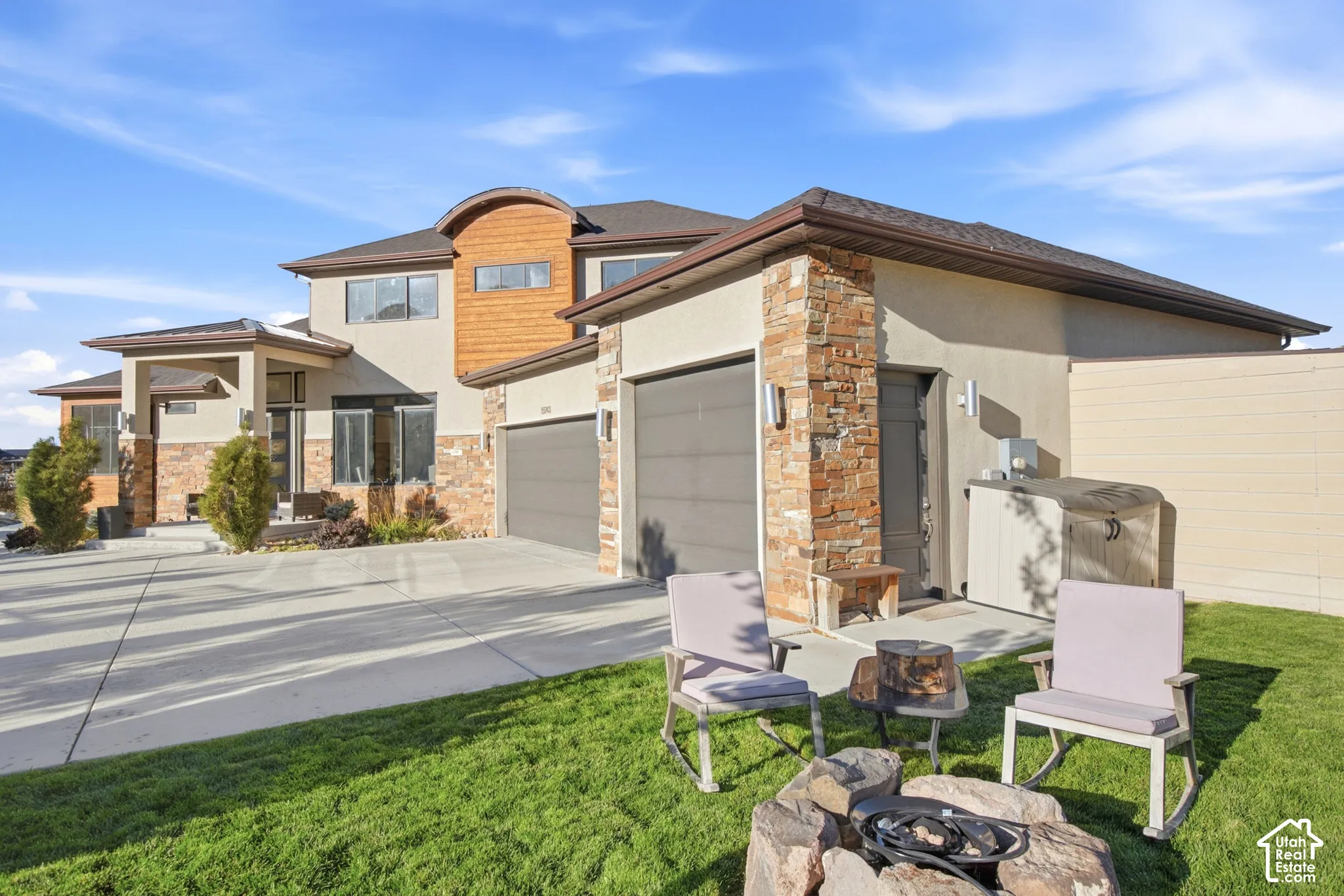 Contemporary exterior featuring stone accents, a multi-car garage, and a concrete driveway