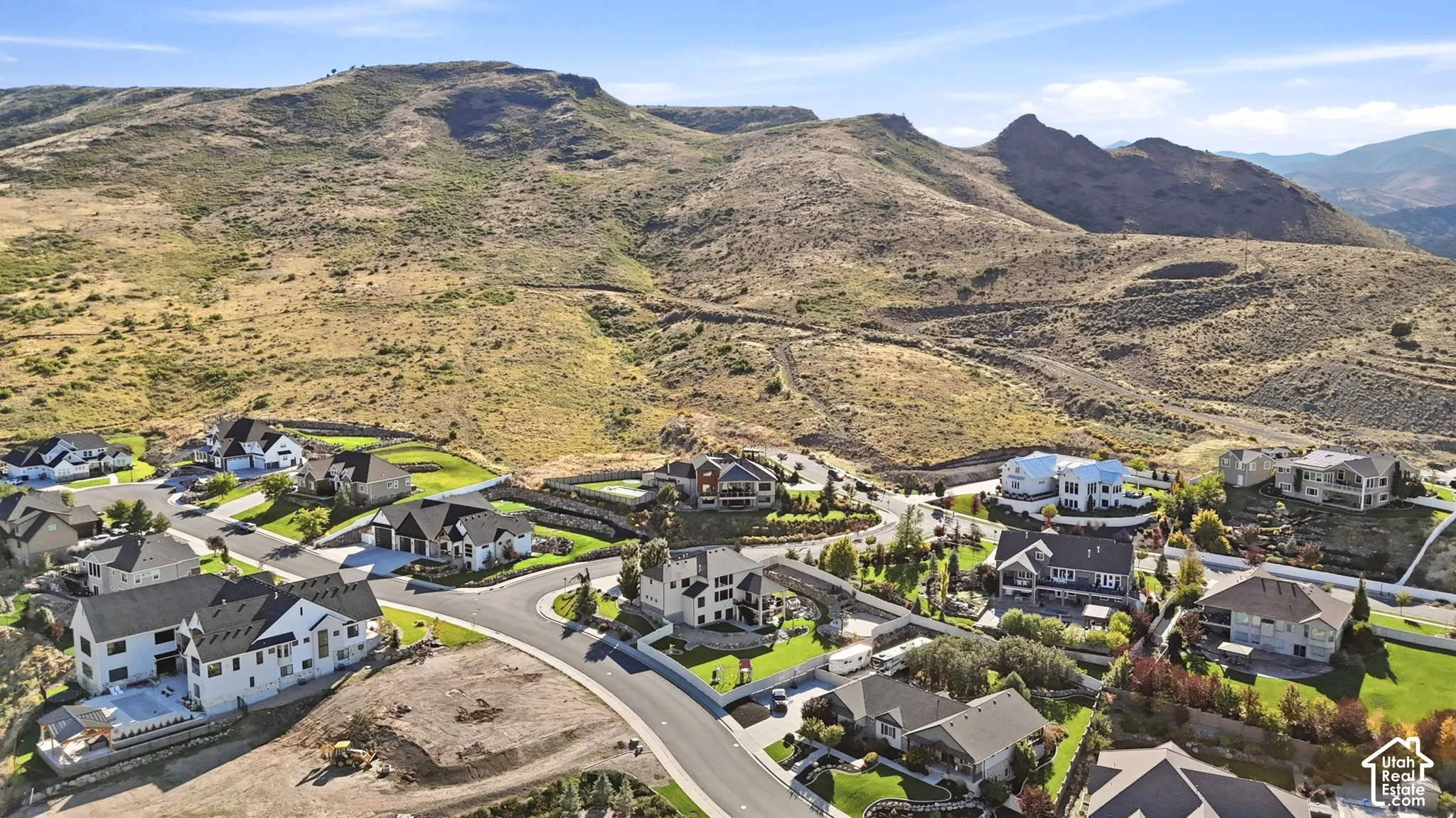 Residential development with modern homes, paved streets, and a mountainous backdrop