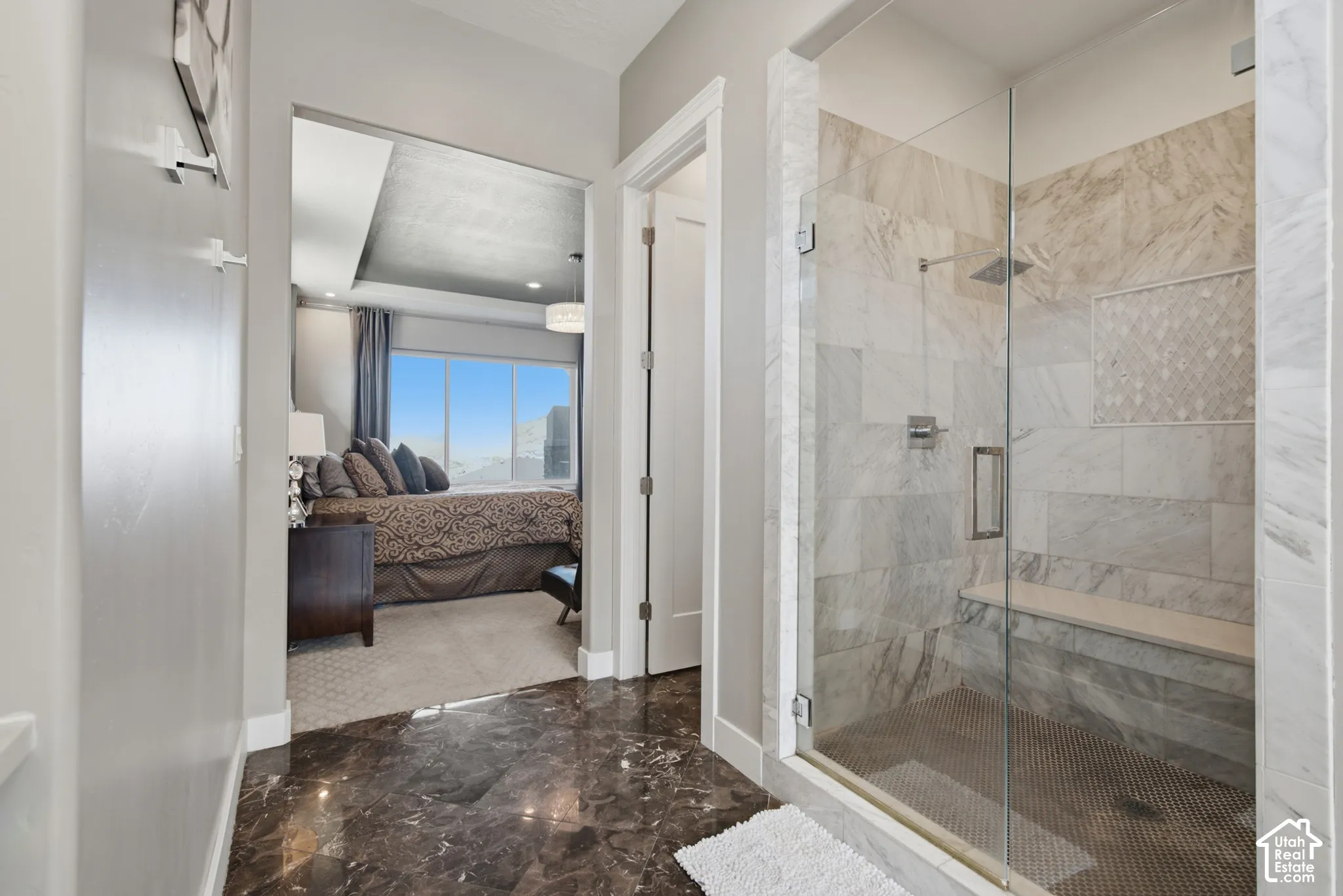 Glass-enclosed shower with a built-in bench, geometric accent tile, and a rainfall showerhead