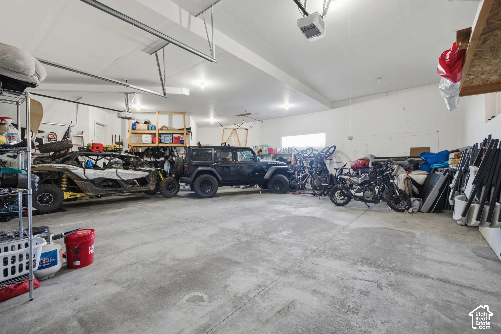 Spacious garage with high ceilings, multiple overhead garage doors, and a concrete floor