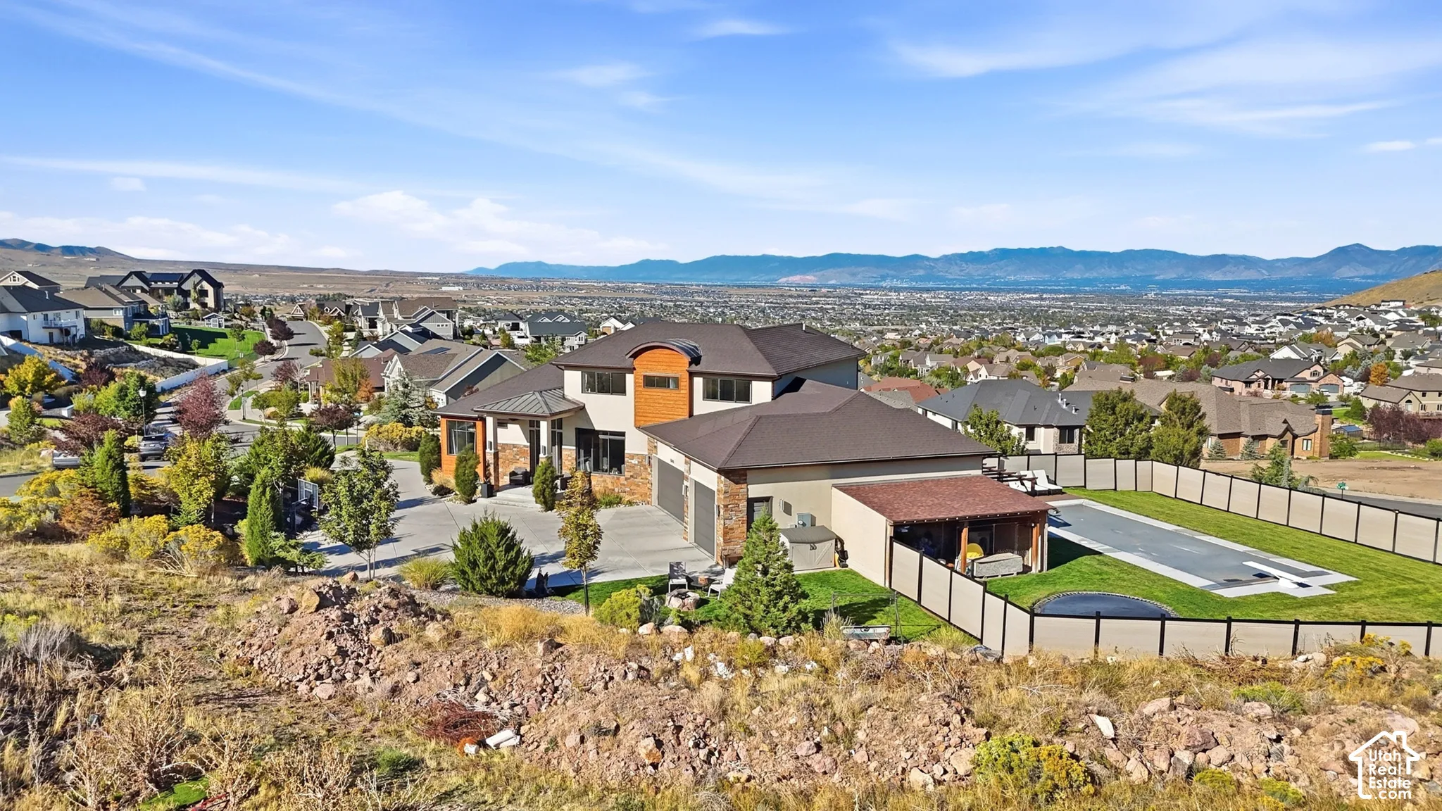 Multi-level residence featuring a brown tile roof and an attached three-car garage