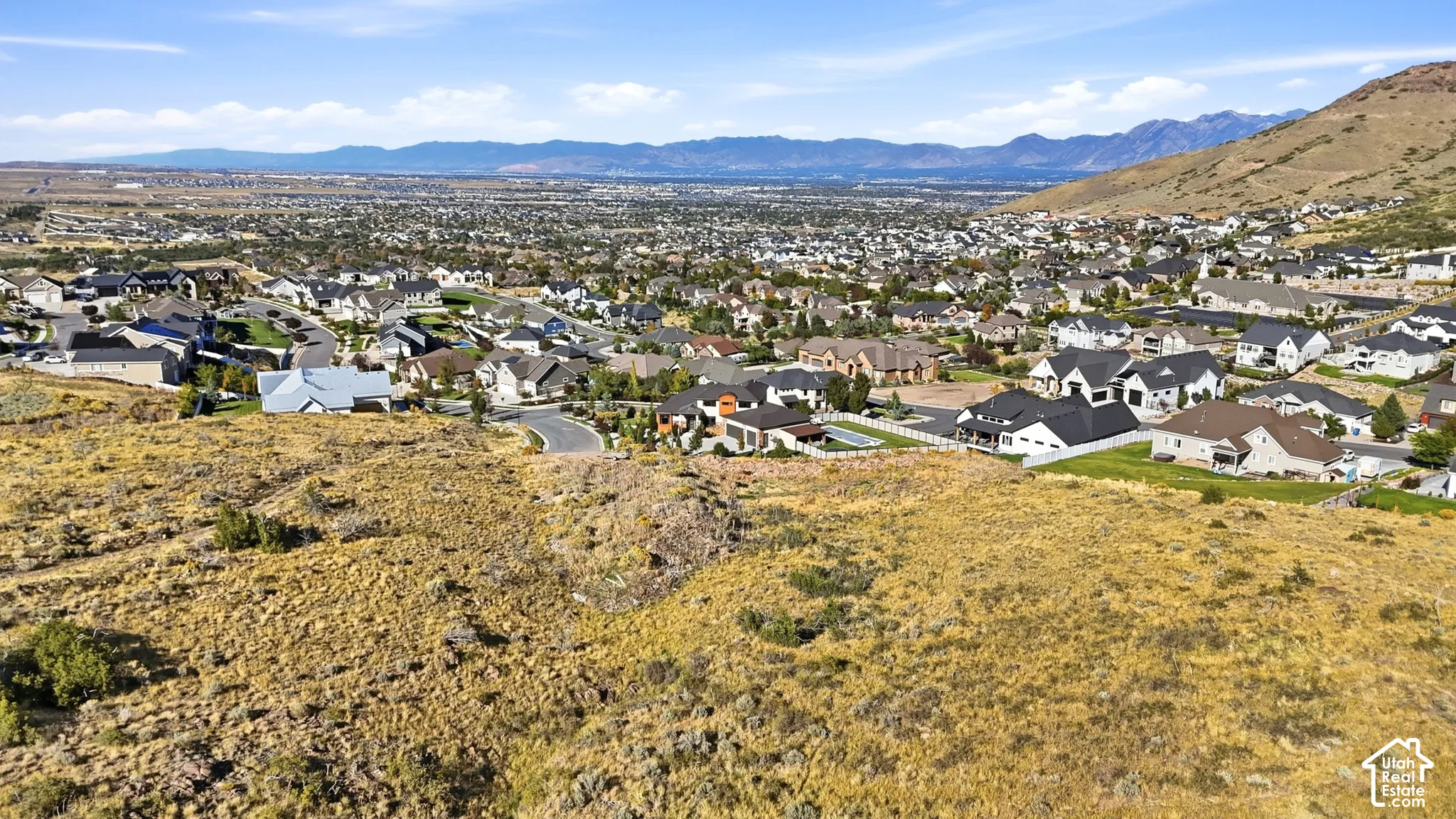 Expansive aerial view showcasing a residential community nestled against a mountainous backdrop