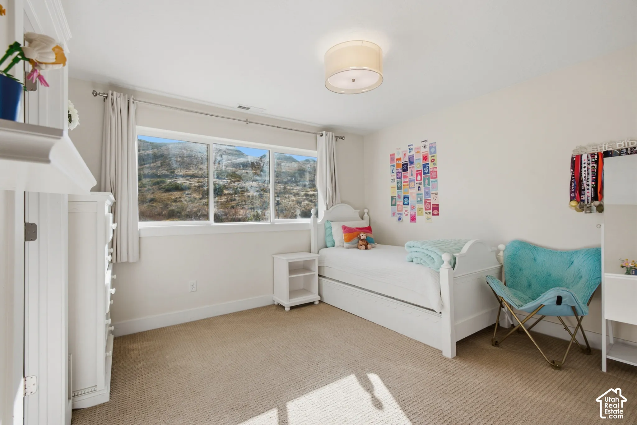Wall-to-wall carpeting, white painted walls, a large window with a mountain backdrop, and a flush mount ceiling light fixture
