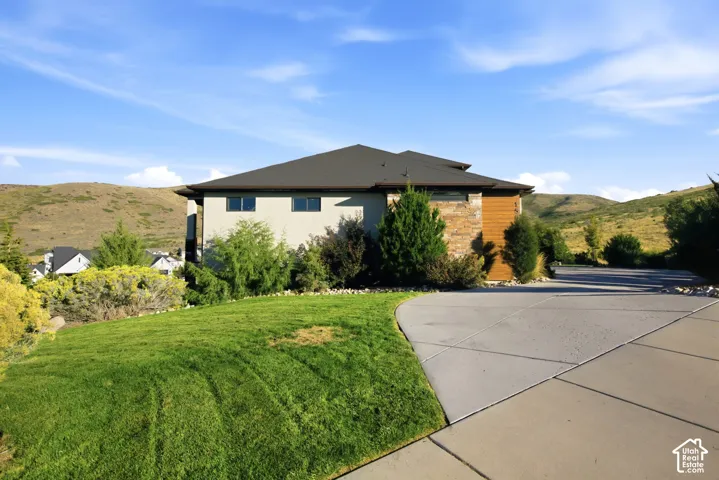 Exterior featuring a dark shingle roof, light-colored siding, and stone accents