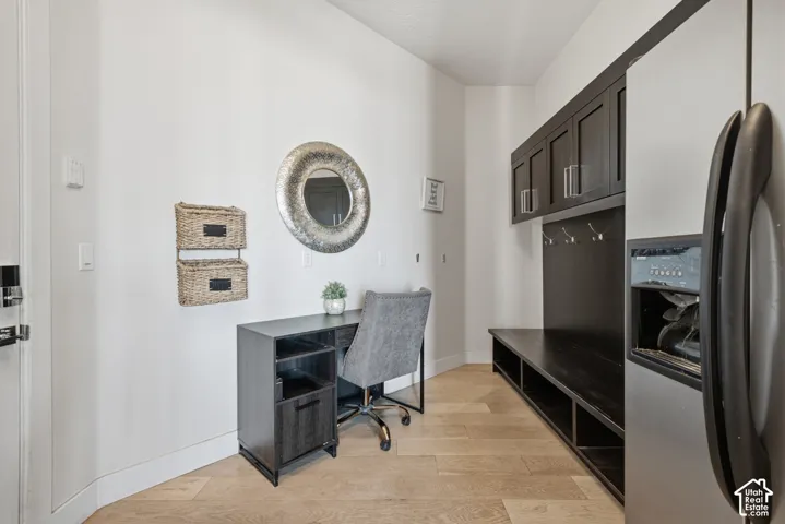 Wood-finish flooring, built-in dark wood cabinetry, dark wood built-in bench seating, dark wood desk, and stainless steel refrigerator