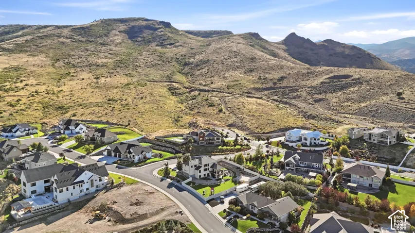 Residential development with modern homes, paved streets, and a mountainous backdrop
