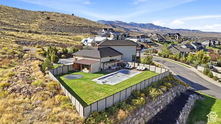 Expansive backyard with a rectangular swimming pool, manicured lawn, and a covered patio
