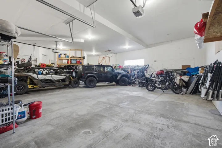 Spacious garage with high ceilings, multiple overhead garage doors, and a concrete floor