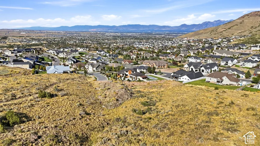 Expansive aerial view showcasing a residential community nestled against a mountainous backdrop