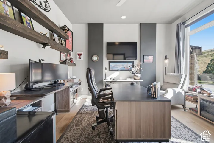 Wood-finish flooring with a large window and custom built-in shelving