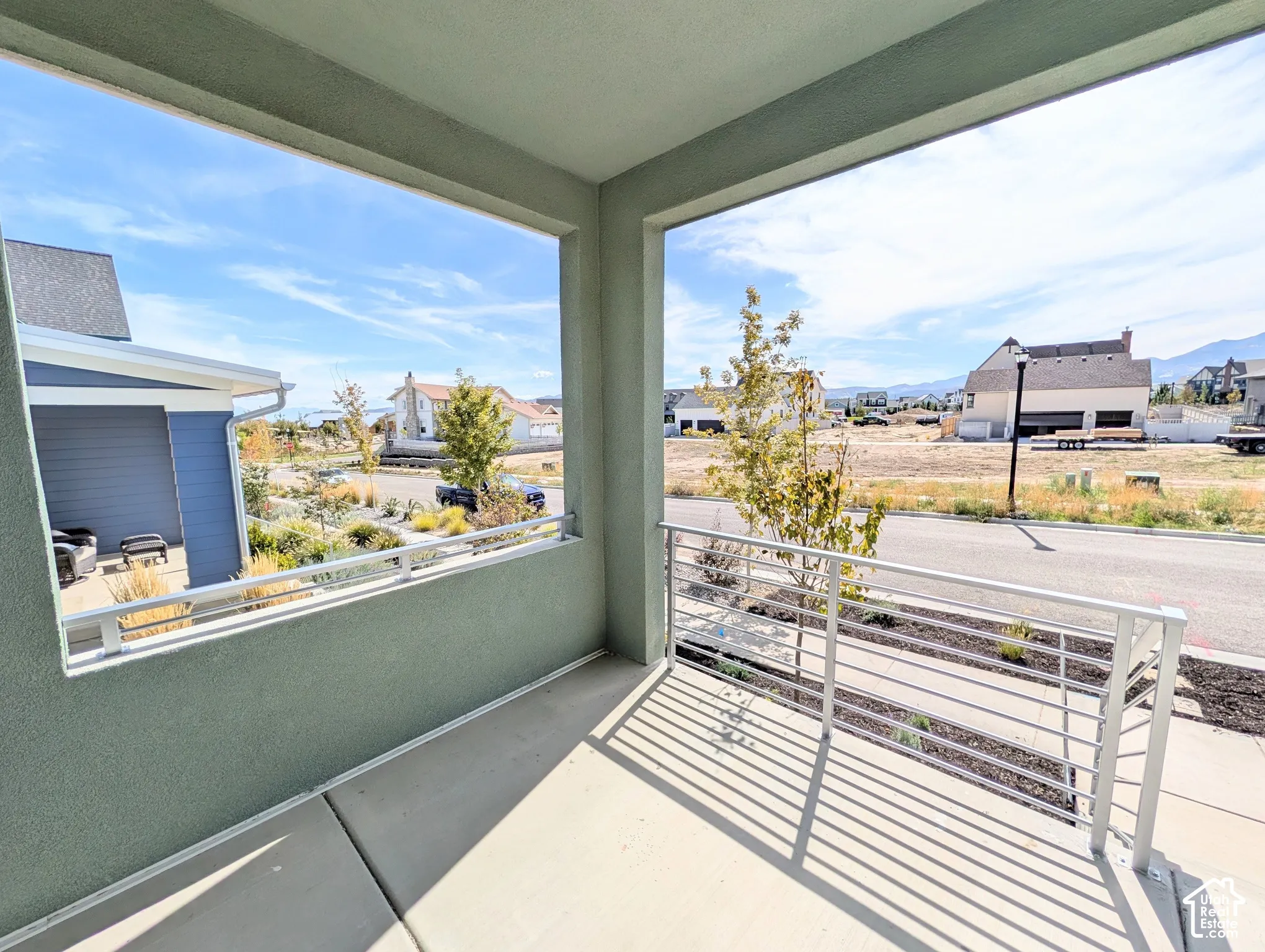 Covered porch with concrete flooring and a linear metal railing