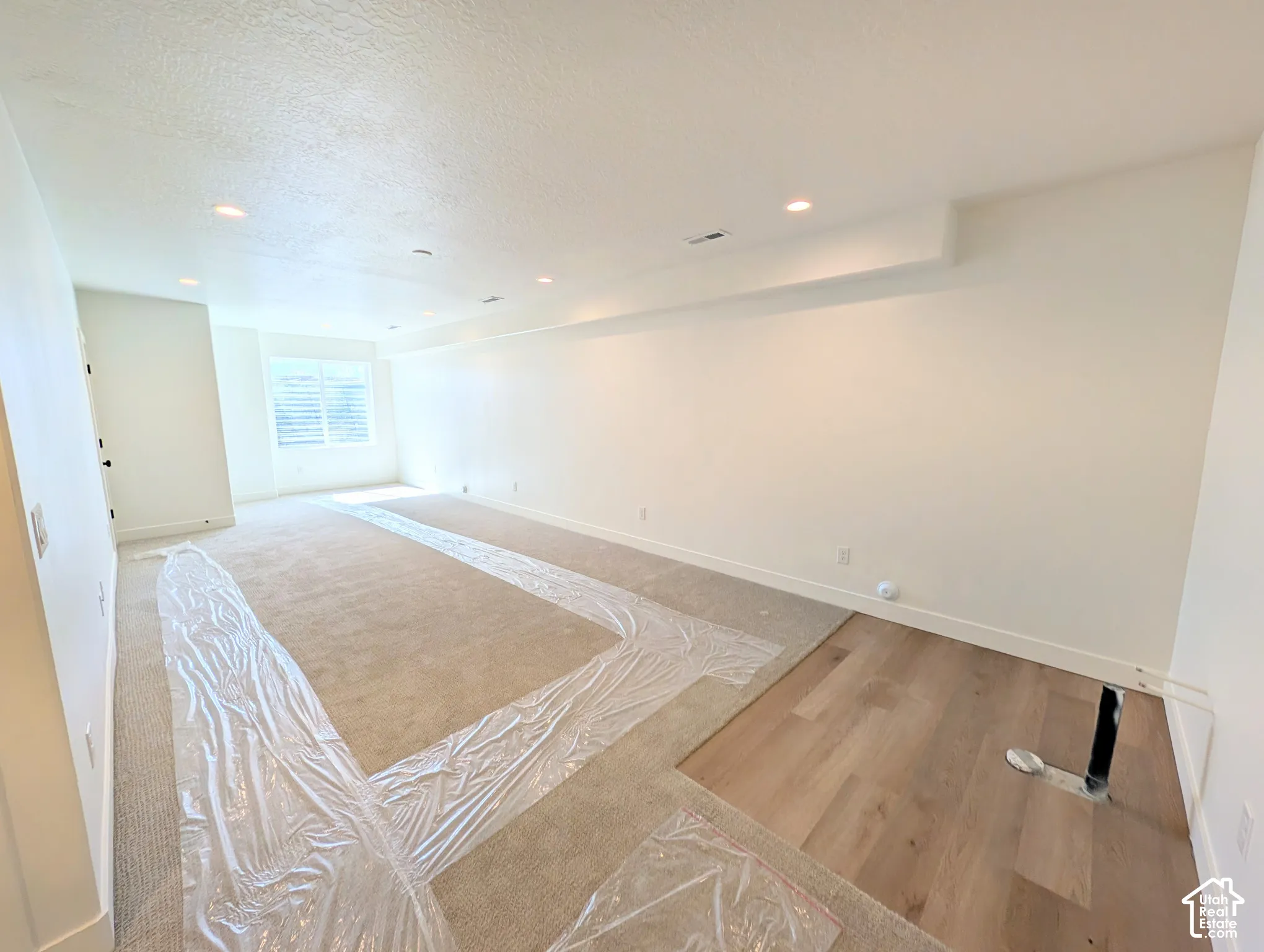 Recessed lighting, wood-finish flooring, and window with horizontal blinds