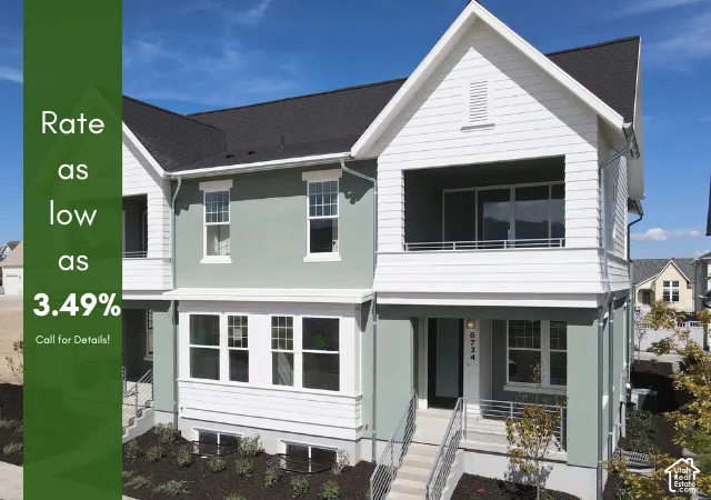 Contemporary townhome exterior featuring light green stucco and white siding