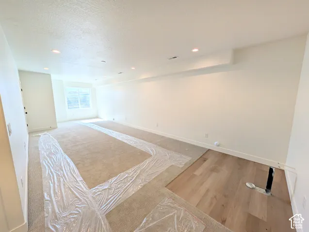 Recessed lighting, wood-finish flooring, and window with horizontal blinds