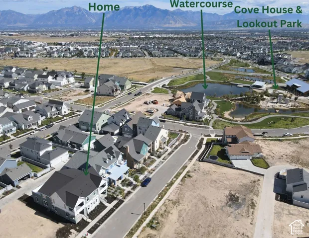 Aerial perspective showcasing a residential community with varied architectural styles, a prominent watercourse, and a designated Cove House & Lookout Park