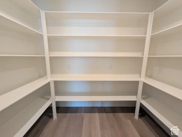 Extensive built-in shelving with multiple levels, U-shaped configuration, light wood-finish flooring, and light-toned walls