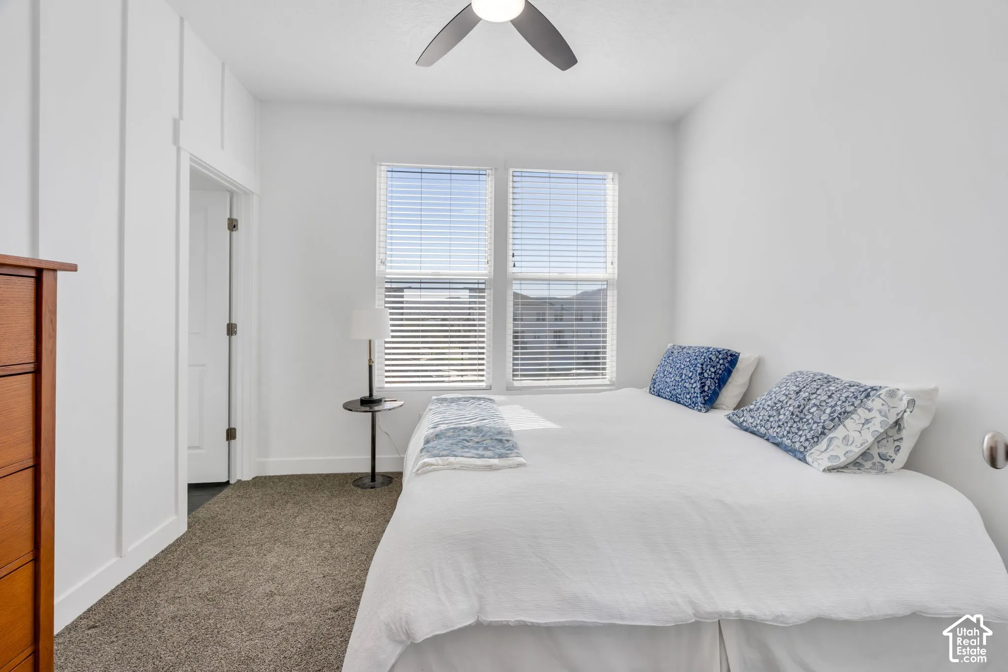 Recessed lighting, ceiling fan, two windows with blinds, white walls, and carpeting