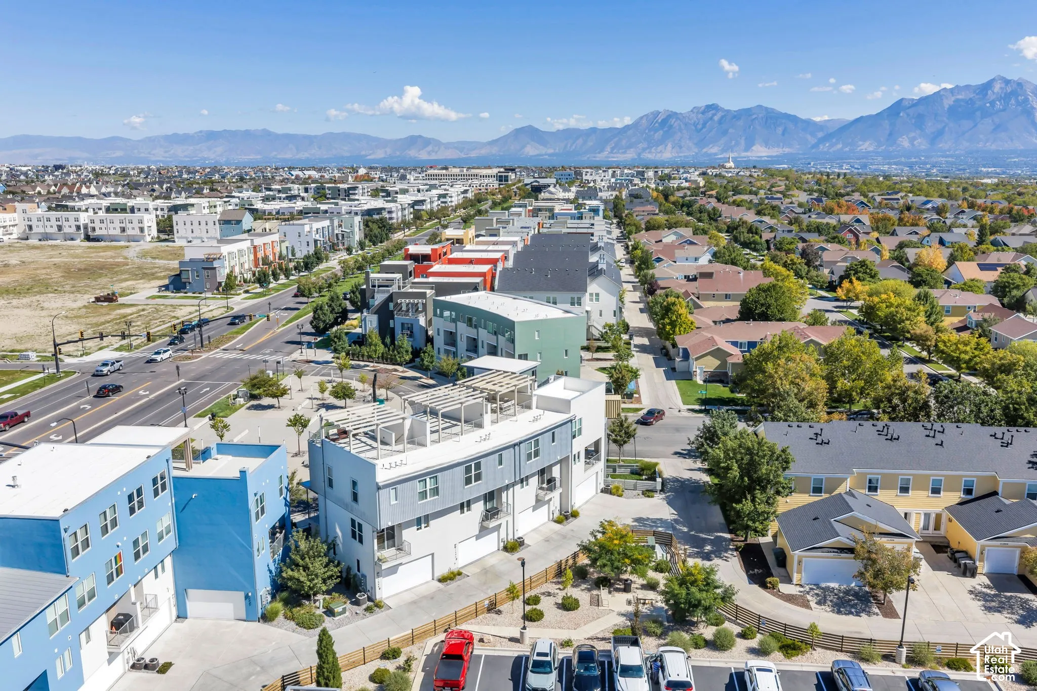 Mountain backdrop, multi-story buildings, established residential areas, commercial thoroughfare, well-maintained landscaping