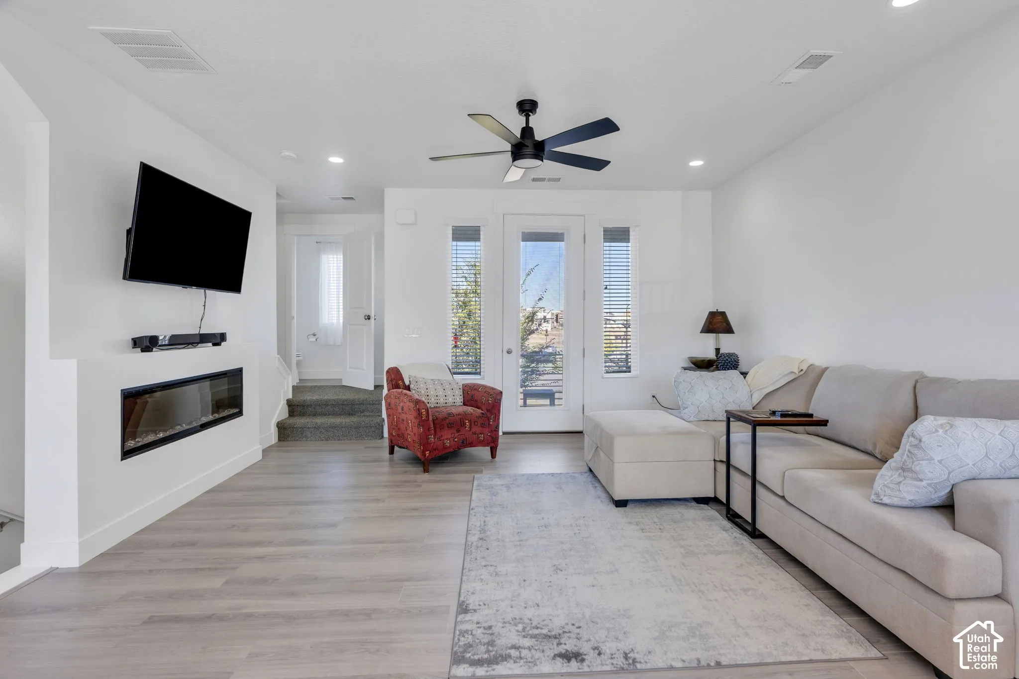 Open concept living area featuring light wood-finish flooring, recessed lighting, and a modern ceiling fan