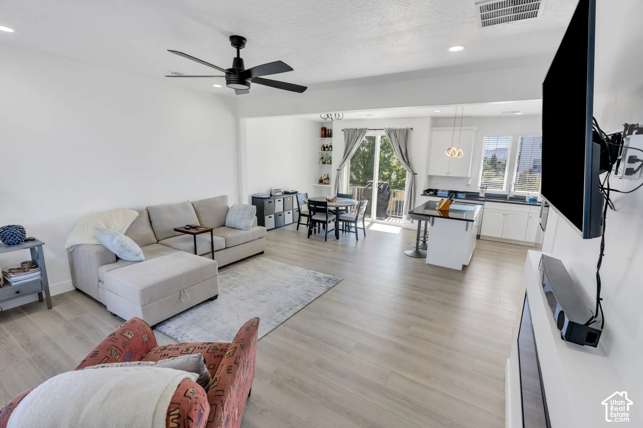 Open-concept living space featuring wood-finish flooring, recessed lighting, and a contemporary ceiling fan