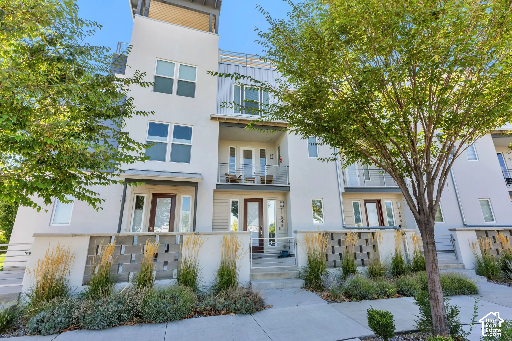 Modern multi-story facade featuring light-colored stucco and horizontal siding accents