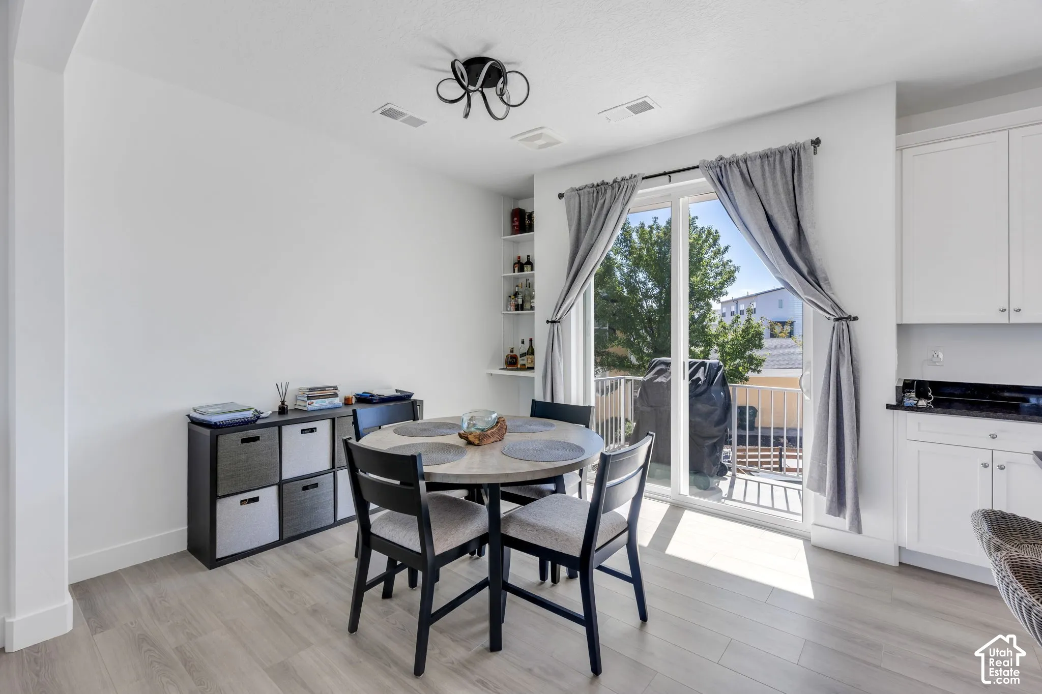 Light wood-finish flooring with a sliding glass door opening to a private balcony