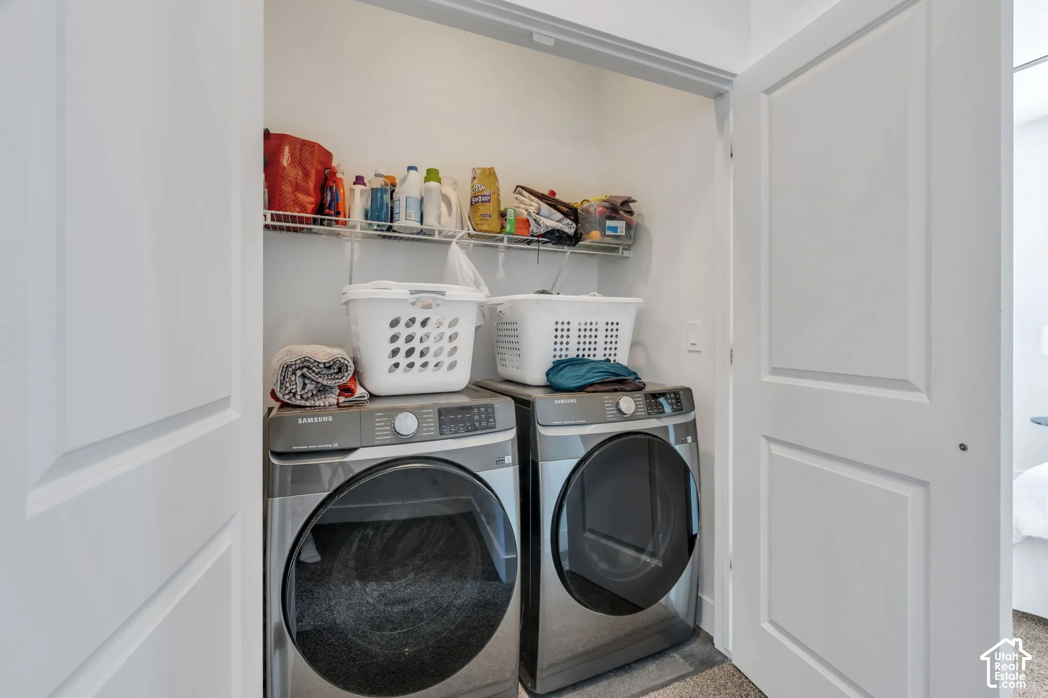Dedicated laundry closet featuring a built-in wire shelf