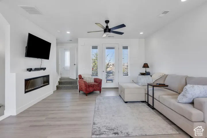 Open concept living area featuring light wood-finish flooring, recessed lighting, and a modern ceiling fan