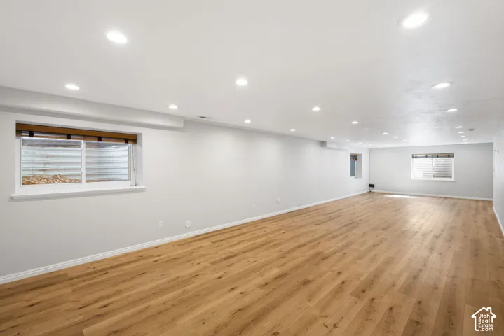 Expansive open room featuring wood-finish flooring, recessed lighting, and multiple windows