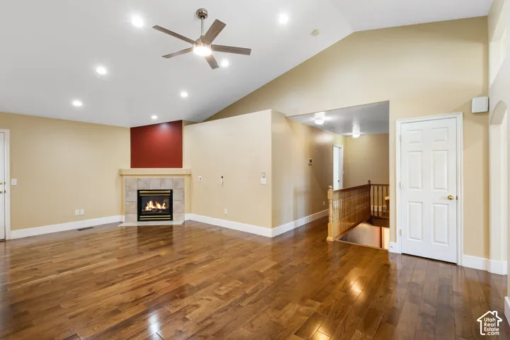 Vaulted ceiling with a ceiling fan, recessed lighting, and wood-finish flooring