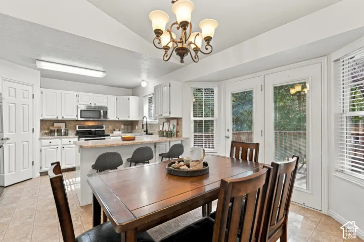 Kitchen with white cabinetry, stainless steel appliances, and a breakfast bar