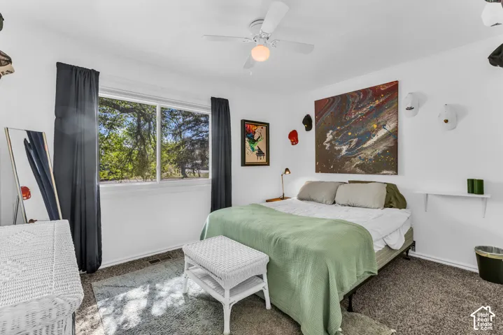 Recessed window with white trim, a ceiling fan with integrated lighting, a built-in wall shelf, and carpet flooring
