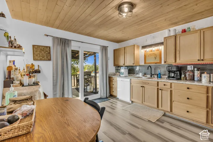 Wood-finish plank ceiling, light wood cabinetry, light countertops, wood-finish flooring, and a sliding glass door
