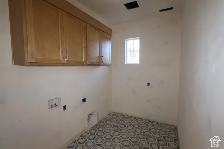 Laundry room with window and built in cabinets for extra stroage.