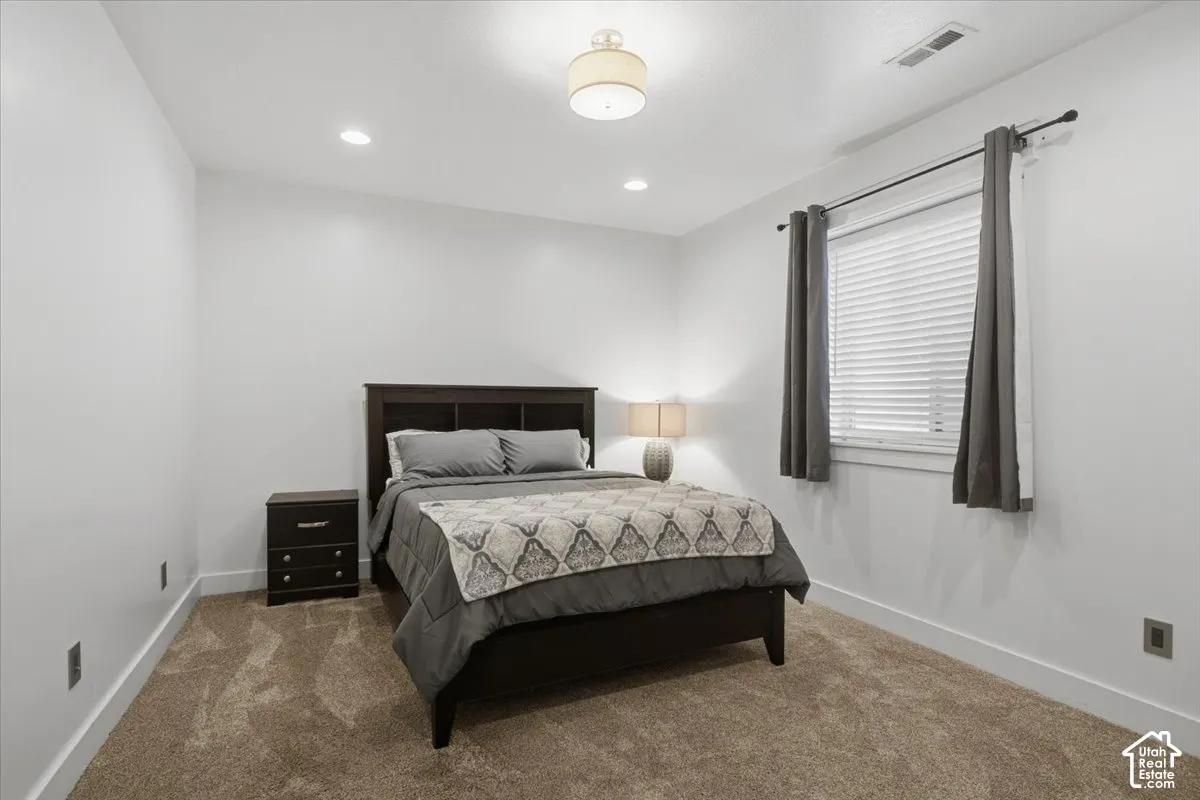 Recessed ceiling lighting, ceiling-mounted light fixture, window with blinds, wall-to-wall carpeting, and bright white wall paint